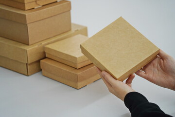 A woman holds cardboard boxes for parcels and delivery