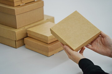 A woman holds cardboard boxes for parcels and delivery
