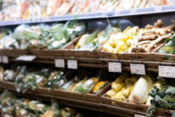 Defocused background with supermarket's shelf with wooden boxes of vegetables. Concept of selling eco-friendly food