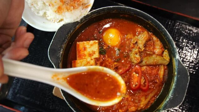 Japanese hot soup call Sukiyaki with slice pork, vegetable, Mushroom and York egg on hot pan.