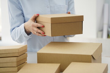 A woman holds cardboard boxes for parcels and delivery