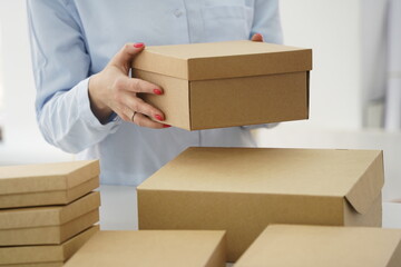 A woman holds cardboard boxes for parcels and delivery