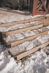 Wooden stairs covered with snow and ice.