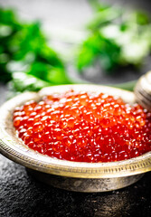 Full bowl of red caviar on the table. 
