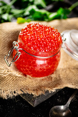 Red caviar on a cutting board with parsley.