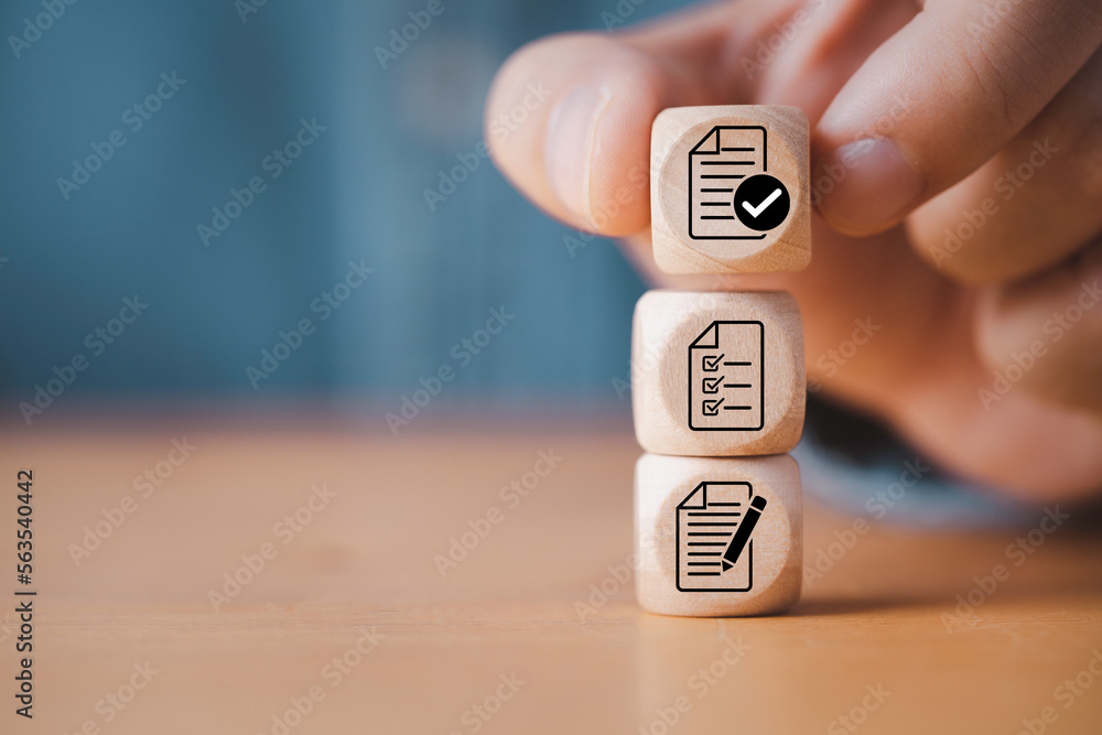Poster Hand stacking document which print screen on wooden cube block for prepare check and approve document , Quality assurance and ISO guarantee concept.