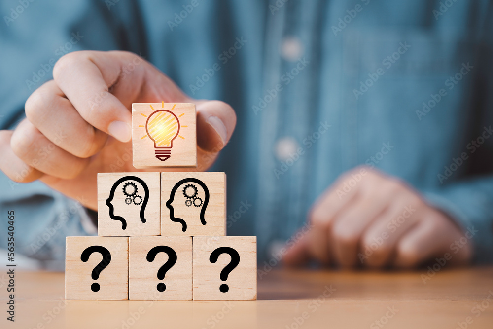 Poster hand putting wooden cube block stacking which print screen glowing light bulb and question mark with
