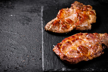 Delicious grilled pork steak on a stone board. 