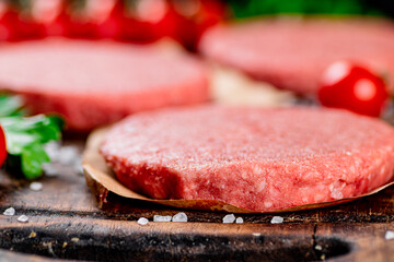 Raw burger with fresh tomatoes. 
