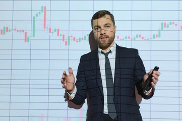 Man is standing near projector and showing graphs and business graphs.