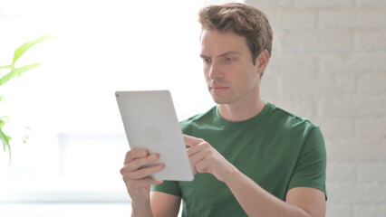 Young Man using Digital Tablet, Browsing Internet