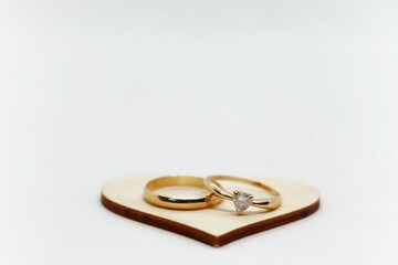 Two golden rings on a wooden heart