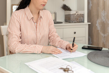 Purchase of real estate. Close up of woman realtor fills documents. Concept of leasing and mortgage