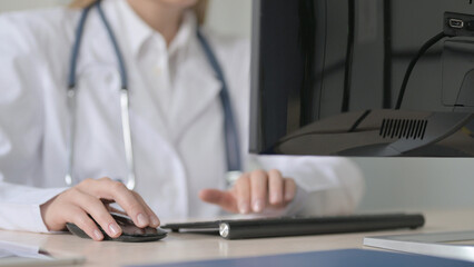 Close up of Female Doctor Working on Desktop Computer in Clinic