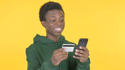 Online Shopping by Young African Man on Yellow Background