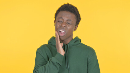 Young African Man having Toothache on Yellow Background