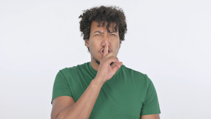 Fototapeta na wymiar African Man with Finger on Lips, Silence on White Background