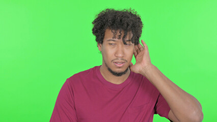 African Man Listening Secret Information on Green Background