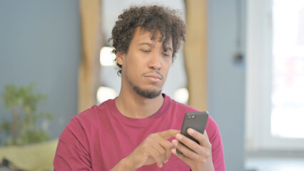 Fototapeta na wymiar African Man using Smartphone for Browsing Internet