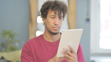 African Man Browsing Internet on Digital Tablet