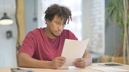 African Man Working on Documents in Office, Paperwork