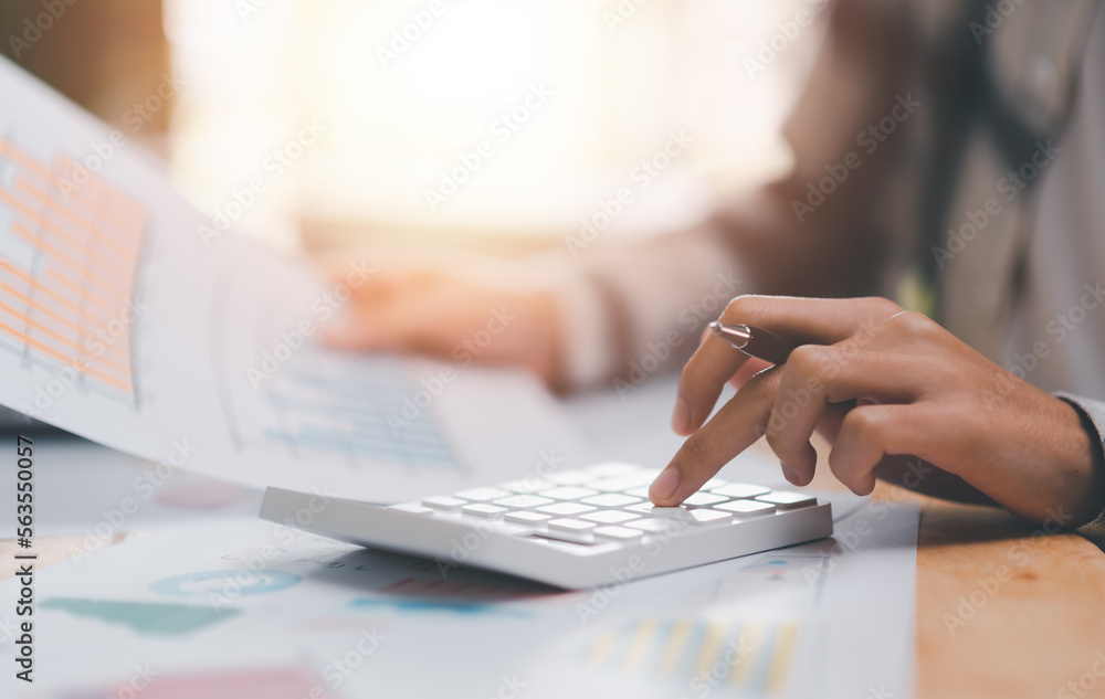 Poster businessman calculating figures in company financial documents with a calculator,analysis of company