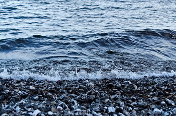 Obraz premium Sea waves meet gravel beach