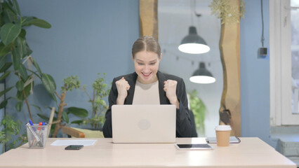 Businesswoman Celebrating Online Success on Laptop in Office