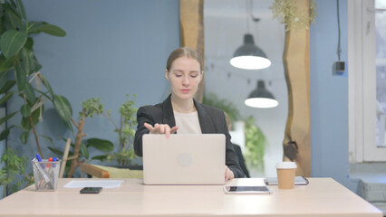 Businesswoman Leaving Office after Closing Laptop