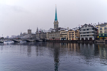 Beautiful cityscape of the old town of Zürich with protestant church Women's Minster, Minster Bridge and Limmat River in the foreground. Photo taken December 16th, 2022, Zurich, Switzerland.
