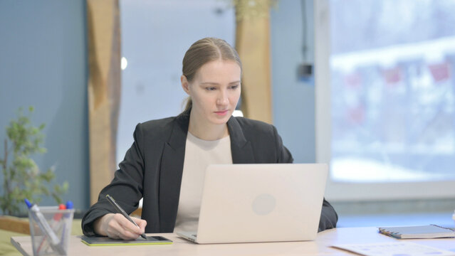 Female Graphic Designer Working on Laptop and Graphic Tablet