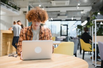 Stylish male freelancer working on new startup project making internet researchers analyzing data using laptop