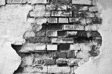 Texture of old brick wall with collapsed plaster. Background of shabby building. Destroyed concrete and brick wall with fallen plaster. Black and white photo. Copy space. Selective focus.