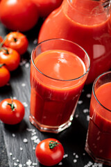 Tomato juice on a stone board with pieces of salt. 