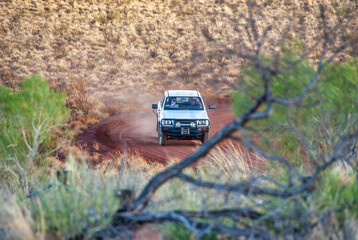 White car driving along an australian outback road