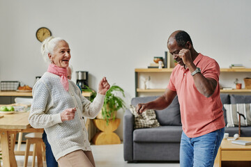 Multiethnic senior couple having fun during dancing lesson in the room