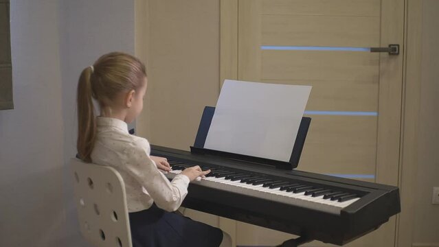 little girl plays the synthesizer. place for advertising. High quality FullHD footage