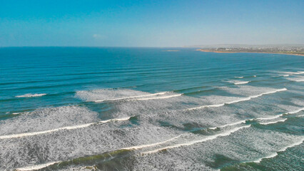 Fototapeta na wymiar Aerial view of gentle waves along the beautiful shoreline