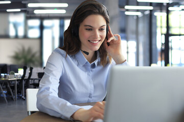 Freelance operator talking with headsets and consulting clients from office.