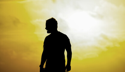 Obraz premium Silhouette of a man looking to the sea on the beach