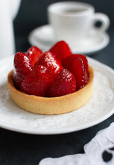 Strawberry tart.  Buttery crust pastry with a creamy filling and a topping of fresh berries with a fruit glaze.