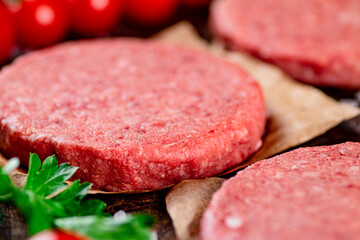 Raw burger with fresh tomatoes. 