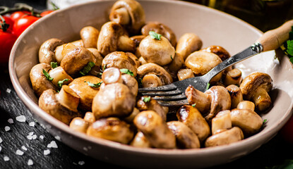 Fried mushrooms in a bowl with cherry tomatoes. 