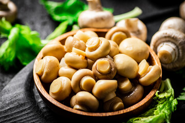 Fragrant pickled mushrooms in a plate with greens. 