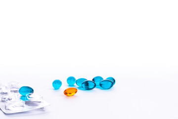Assorted pharmaceutical capsules, blue and orange medication, tablets in different colors denoting different drugs and antibiotics in a health care concept.