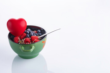 Bowl of healthy fresh berry fruit salad on white background.