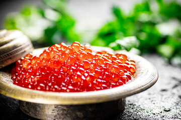 Full bowl of red caviar on the table. 