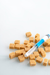 Insulin pen on brown cane sugar in white background (diabetes). Diabetes concept.