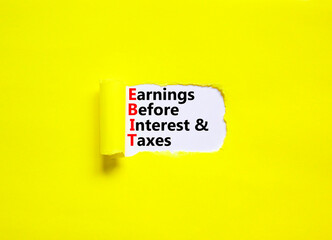 EBIT symbol. Concept words EBIT earnings before interest and taxes on white paper on beautiful yellow background. Business EBIT earnings before interest and taxes concept. Copy space.