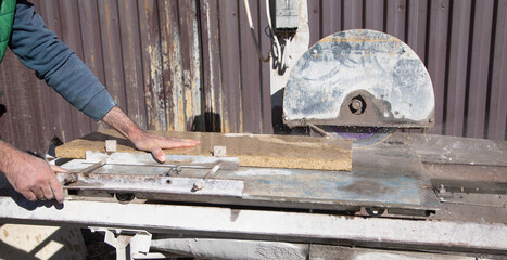 Electric tile cutter. Tiler cutting tile on wet saw machine